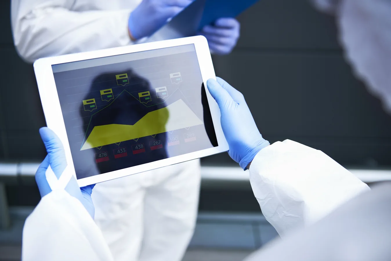 Scientists reviewing contamination control data on a tablet